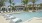 a swimming pool with lounge chairs and palm trees
