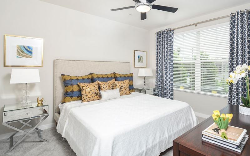 a bedroom with a bed and a fan
