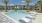 a pool with lounge chairs around it